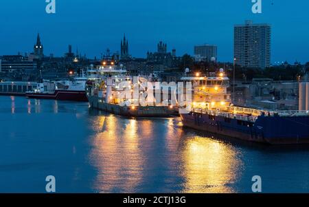 View at sunrise of Aberdeen port with North Sea oil industry offshore support vessels moored, Aberdeenshire, Scotland, UK Stock Photo