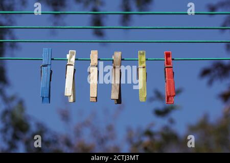Old wooden and plastic pegs on the clothesline. A blue sky. Netherlands, September. Stock Photo