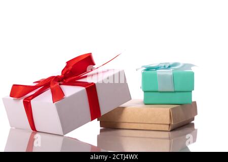 Three cardboard gift boxes with ribbons and bows on glass table surface Stock Photo