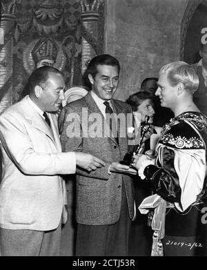 Producer HAL B. WALLIS and RAY MILLAND present LAURENCE OLIVIER with his Oscar for ''HENRY V'' with Art Director CARMEN DILLON watching on set during filming of HAMLET 1948 director LAURENCE OLIVIER play William Shakespeare music William Walton Two Cities Films / General Film Distributors (GFD) Stock Photo