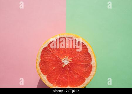 Grapefruit cut in macro, tropical creative minimal food fruit concept, on pink green background.Slice of ripe grapefruit.fruit Ready to Eat.Citrus Stock Photo