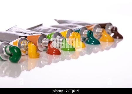Colorful paint tubes squeezed on white sheet of glass Stock Photo