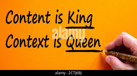 Hand writing 'content is king, context is queen', isolated on beautiful orange background. Business concept, copy space. Stock Photo