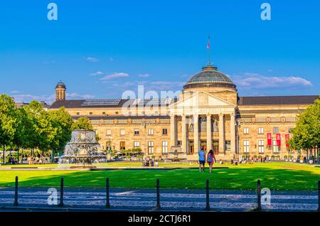 Wiesbaden, Germany, August 24, 2019: Kurhaus or cure house spa and casino building and Bowling Green park with grass lawn, trees alley and pond with fountain in historical city centre, State of Hesse Stock Photo