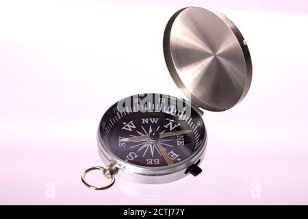 Black compass with open chrome lid pointing to NE or SW isolated on white Stock Photo