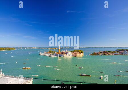 Aerial panoramic view of San Giorgio Maggiore island with Campanile San Giorgio in Venetian Lagoon, sailing boats in Giudecca Canal, Lido island, blue sky background, Venice city, Veneto Region, Italy Stock Photo