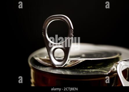 Macro closeup of isolated shiny metal food can with black background (focus on center of pull-tab) Stock Photo