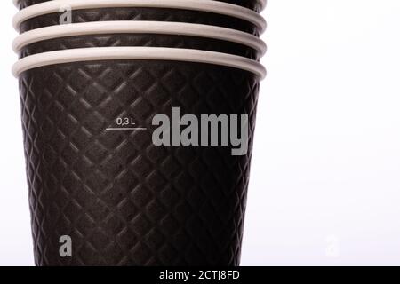 Stack of stylish black paper cups on isolated white background. Mug of 300 ml Stock Photo