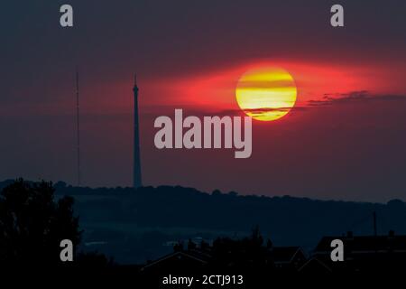 The Sun sets over Emley Moor transmitting station near Huddersfield, West Yorkshire as the country braces itself as weather warnings have been issued for thunder storms Stock Photo