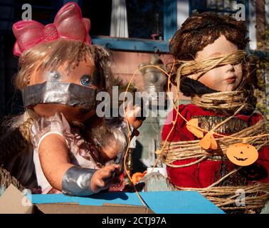 Creepy baby dolls. Outside Halloween decoration. A baby doll with mouth taped. A doll with bound eyes. Stock Photo