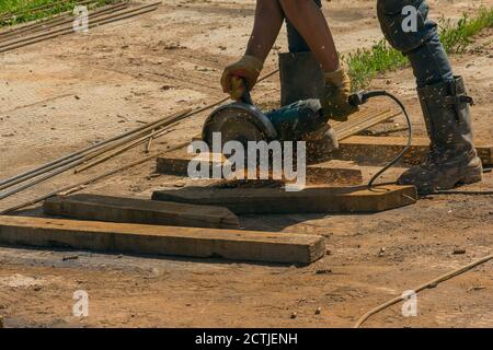 Close up of metal worker using angle grinder. Parts procurement. Metalworking Stock Photo