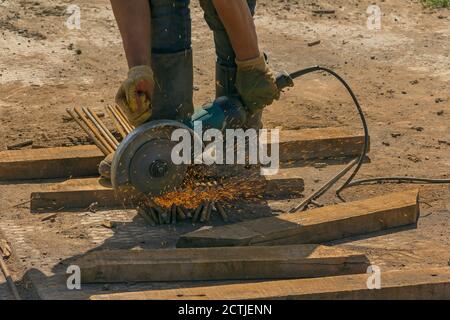 Close up of metal worker using angle grinder. Parts procurement. Metalworking Stock Photo