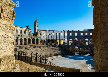 Pula arena with church tower in the background and blue sky Stock Photo