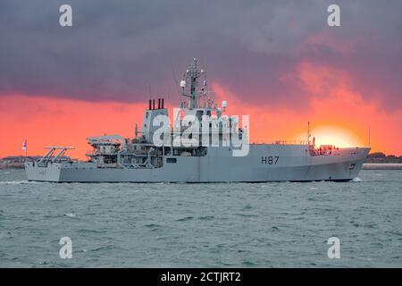 The Royal Navy survey ship HMS Echo (H87) arriving at Portsmouth, UK on the 23rd September 2020 with a dramatic golden hour sunset in the background. Stock Photo