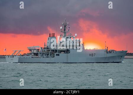 The Royal Navy survey ship HMS Echo (H87) arriving at Portsmouth, UK on the 23rd September 2020 with a dramatic golden hour sunset in the background. Stock Photo