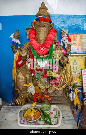 Ganesha Statue with offering. Elephant headed Hindu God of beginnings, remover of obstacles in the Gangaramaya Temple, Colombo, Sri Lanka. Stock Photo