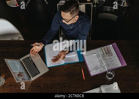 Young man studying from home, using laptop Stock Photo
