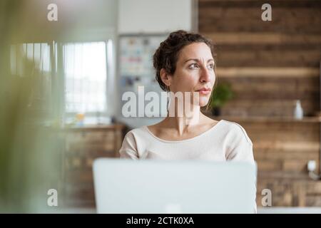 Close-up of female entrepreneur looking away while using laptop Stock Photo