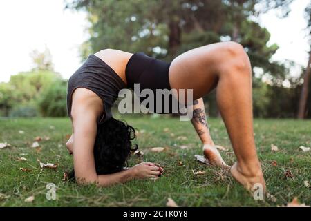 Young woman practicing contortion in park Stock Photo