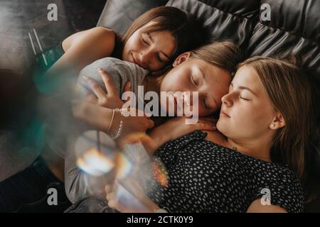 Friends sleeping on sofa bed at home Stock Photo