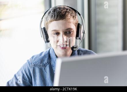 Businesswoman wearing headset at desk in office Stock Photo