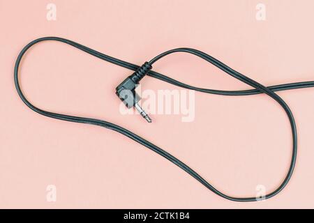 Connector jack plug and its cord in a pink pale background Stock Photo