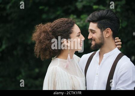Lovely couple looking at each other while standing at garden Stock Photo