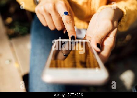 Midsection of young woman using smart phone in city Stock Photo
