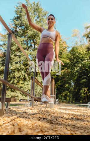 Woman balancing on rope on a fitness trail Stock Photo