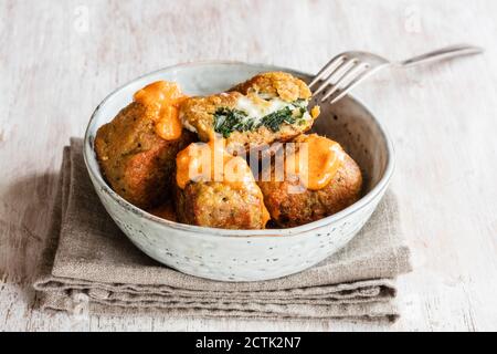 Bowl of fried spinach balls with tomato sauce Stock Photo