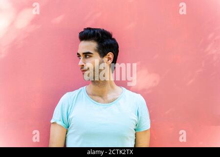 Thoughtful man looking away against wall Stock Photo
