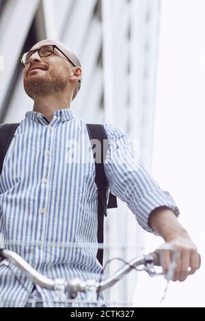 Low angle view of man standing with bicycle Stock Photo