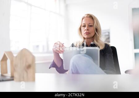 Female professional using digital tablet at desk in home office Stock Photo