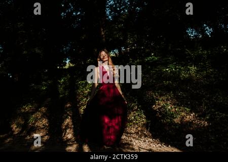 Thoughtful woman standing in forest Stock Photo