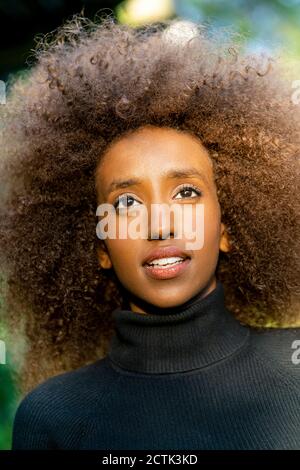 Close-up of thoughtful businesswoman with curly frizzy hair looking away Stock Photo