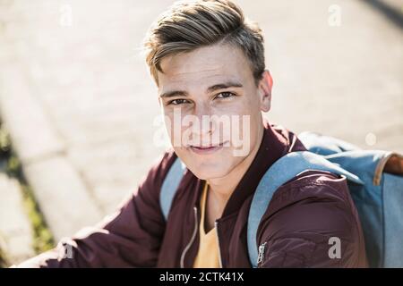 Handsome young man in casuals sitting outdoors Stock Photo