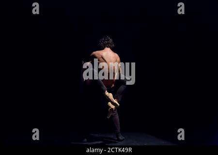 Male and femal dancer performing contemporary ballet on black stage Stock Photo