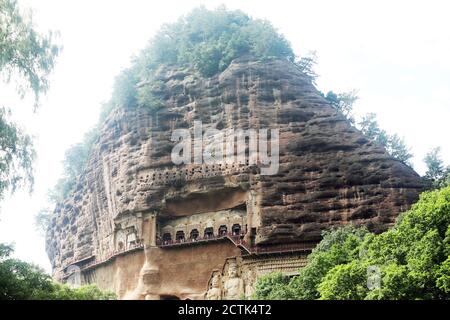 Sculptures of Buddhas are seen on the half of the mountain at the Maijishan Grottoes, a series of 194 caves cut in the side of the hill of Majishan, T Stock Photo