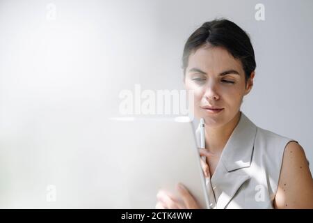 Thoughtful businesswoman using digital tablet at office Stock Photo