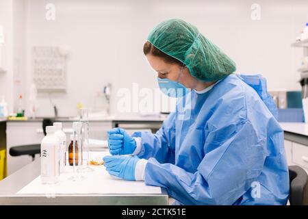 Female pharmacist preparing medicines on table in laboratory Stock Photo