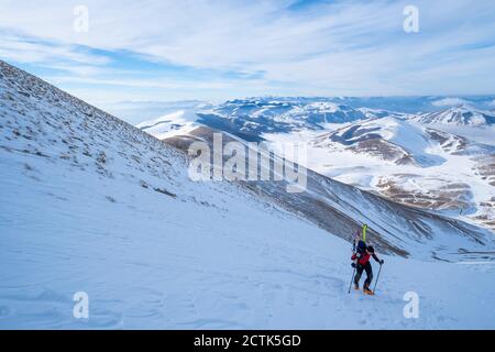 Young man hiking on Sibillini mountain against sky, Umbrian, Italy Stock Photo