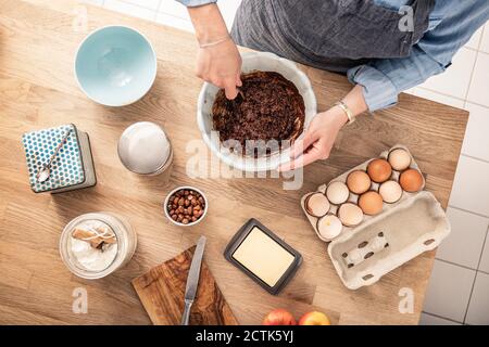 Woman mixing cake batter while standing at kitchen island Stock Photo