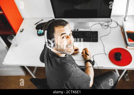 Man sitting on desk with headset working at home Stock Photo