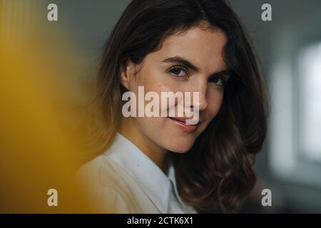 Smiling young woman standing at office Stock Photo