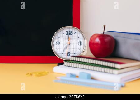 Close-up of alarm clock with school supplies on table Stock Photo