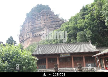 Sculptures of Buddhas are seen on the half of the mountain at the Maijishan Grottoes, a series of 194 caves cut in the side of the hill of Majishan, T Stock Photo