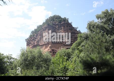 Sculptures of Buddhas are seen on the half of the mountain at the Maijishan Grottoes, a series of 194 caves cut in the side of the hill of Majishan, T Stock Photo