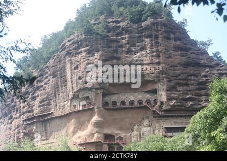 Sculptures of Buddhas are seen on the half of the mountain at the Maijishan Grottoes, a series of 194 caves cut in the side of the hill of Majishan, T Stock Photo