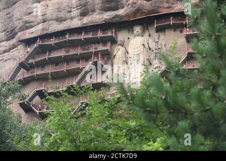 Sculptures of Buddhas are seen on the half of the mountain at the Maijishan Grottoes, a series of 194 caves cut in the side of the hill of Majishan, T Stock Photo