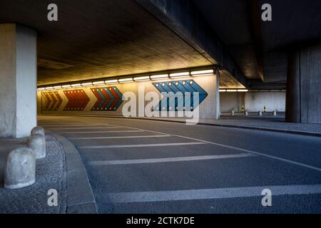 Germany, Berlin, Illuminated tunnel and empty asphalt road at Berlin Tegel Airport Stock Photo